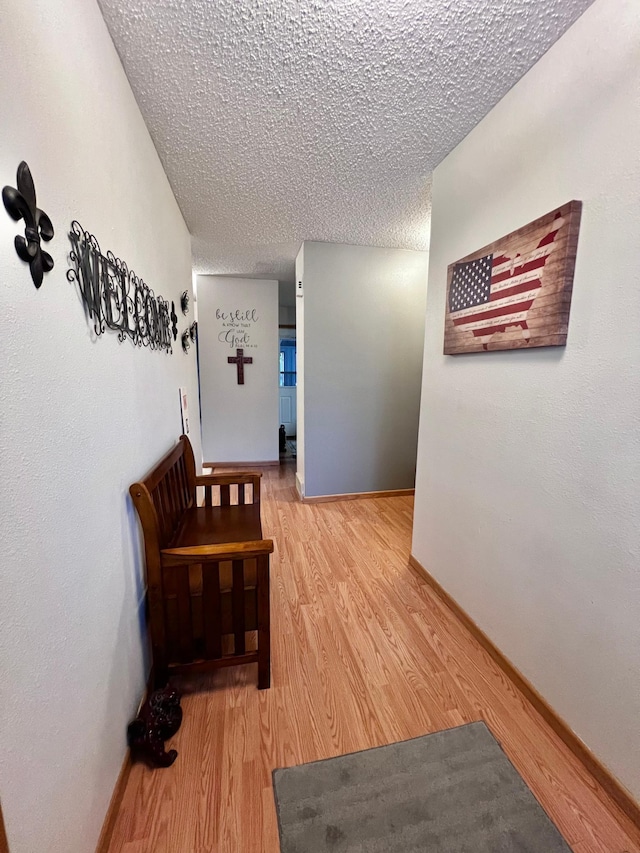 corridor featuring hardwood / wood-style floors and a textured ceiling