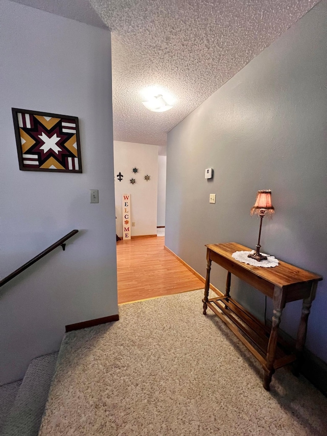 hall featuring a textured ceiling and hardwood / wood-style flooring