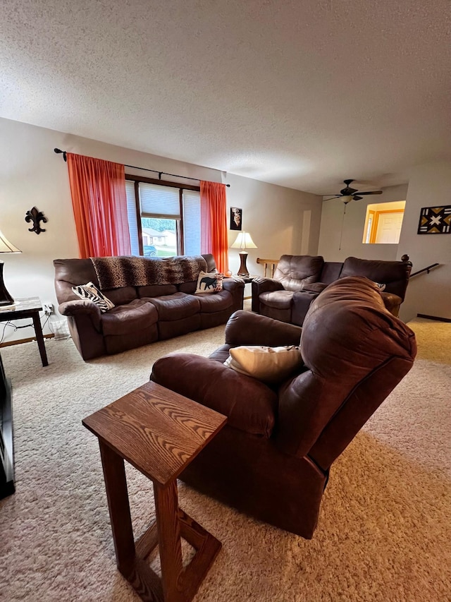 living room featuring ceiling fan, carpet floors, and a textured ceiling