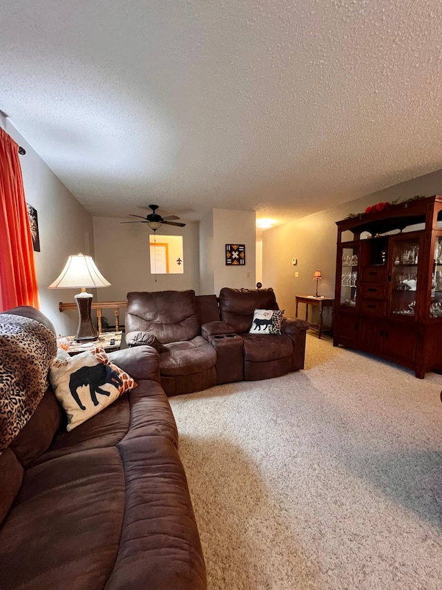 living room with carpet flooring, ceiling fan, and a textured ceiling