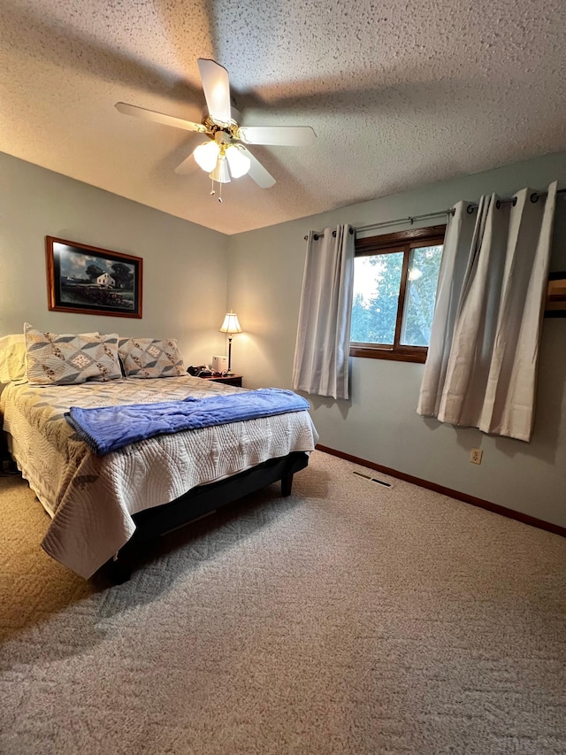 carpeted bedroom with a textured ceiling and ceiling fan