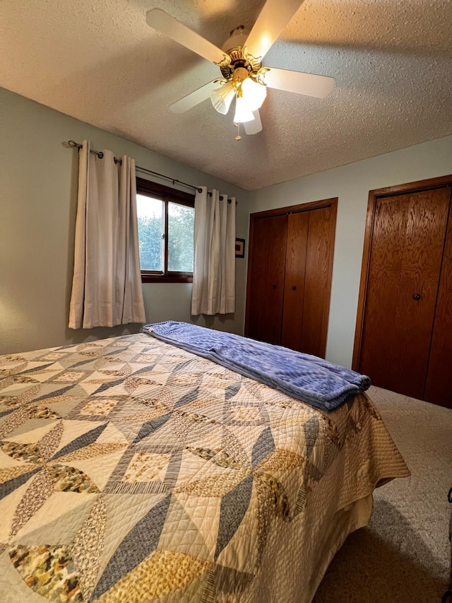 bedroom with carpet, a textured ceiling, and ceiling fan