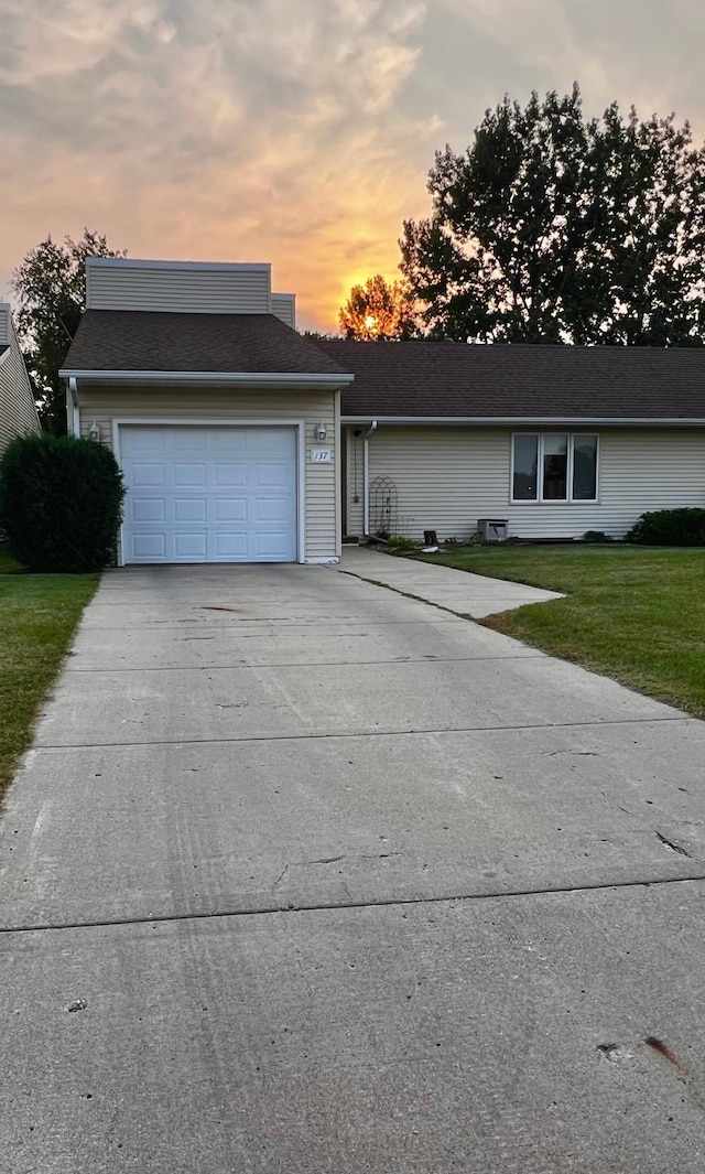 ranch-style house with a yard and a garage