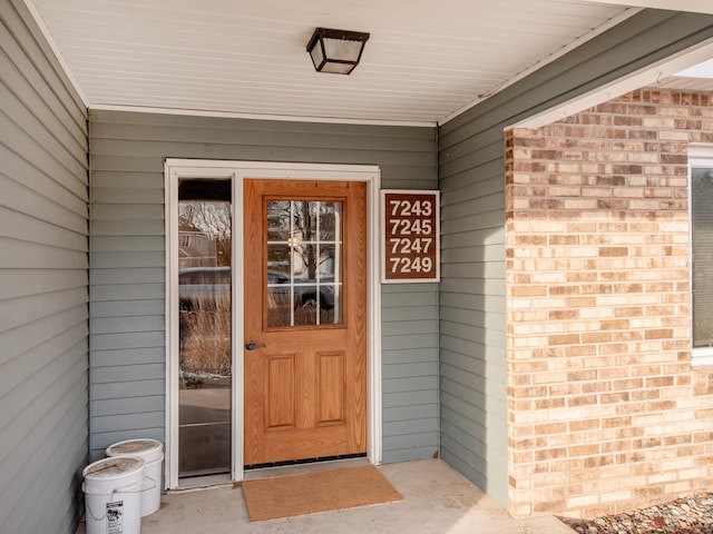 doorway to property featuring brick siding