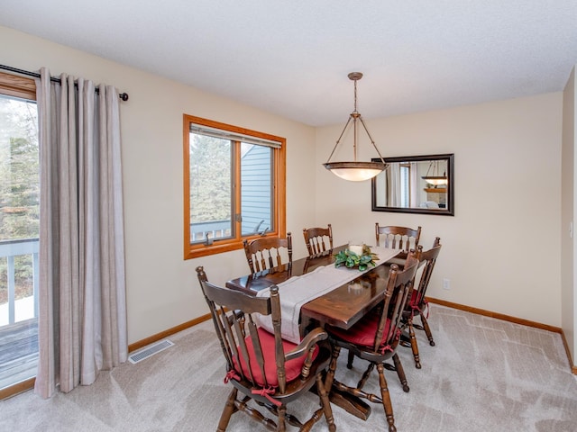 dining area with baseboards, light carpet, and visible vents