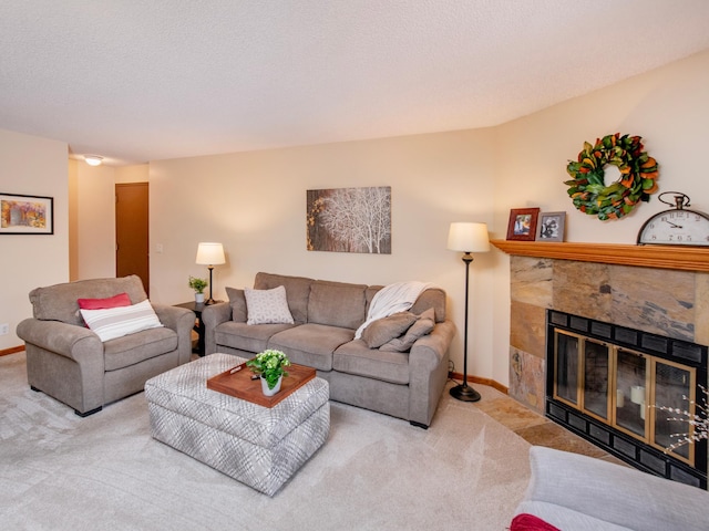 carpeted living room featuring baseboards, a textured ceiling, and a stone fireplace