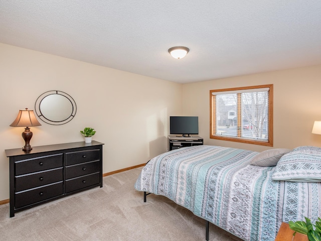 carpeted bedroom featuring a textured ceiling and baseboards