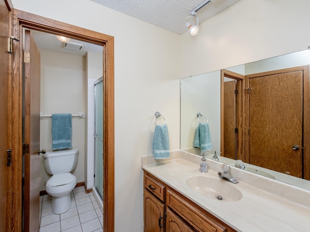 full bathroom with a shower stall, toilet, vanity, tile patterned floors, and a textured ceiling