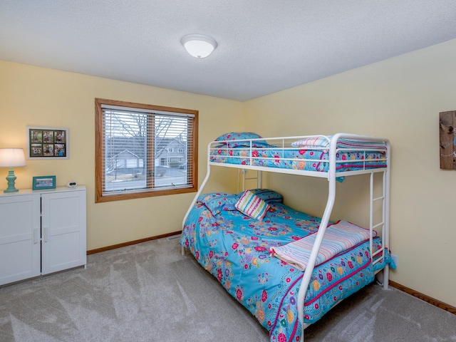 bedroom featuring baseboards, a textured ceiling, and carpet flooring