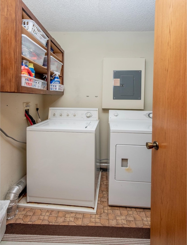 laundry room with washer and dryer, laundry area, electric panel, and a textured ceiling