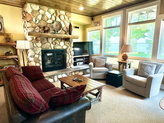 carpeted living room with a stone fireplace and wooden ceiling