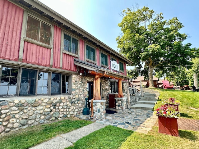 view of front of property with a front lawn and stone siding