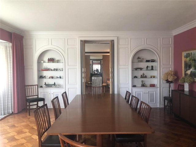 dining room with built in features, plenty of natural light, and crown molding