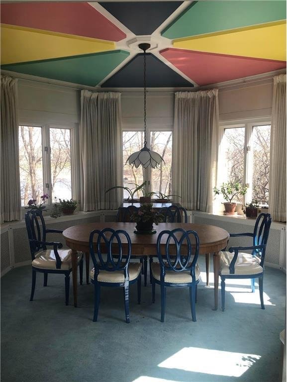 carpeted dining space featuring a healthy amount of sunlight and french doors