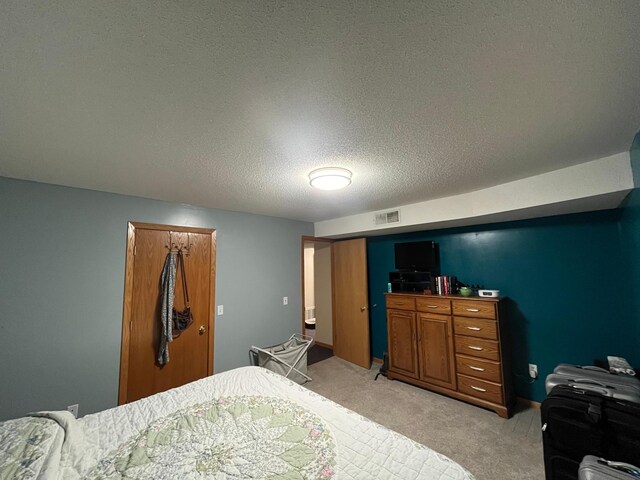 bedroom featuring a textured ceiling and light carpet