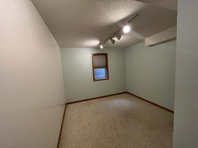 spare room featuring a textured ceiling and track lighting