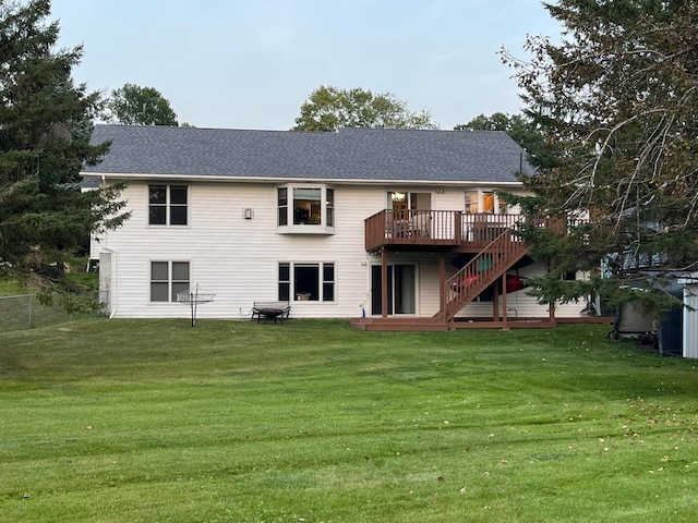 back of property with a lawn and a wooden deck