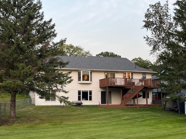 back of property with a lawn and a deck