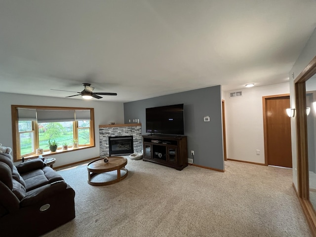 living room with a fireplace, ceiling fan, and light colored carpet