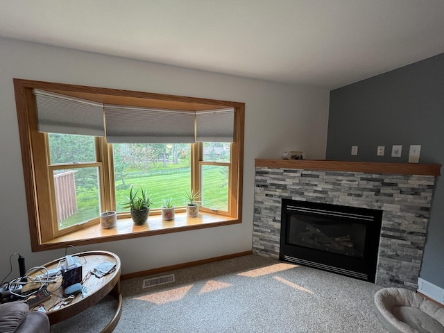 living room featuring carpet floors, a fireplace, and plenty of natural light