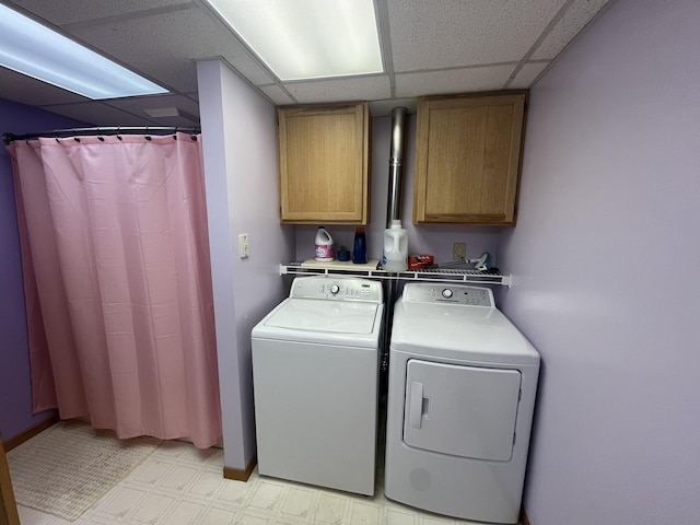 washroom featuring washer and clothes dryer and cabinets