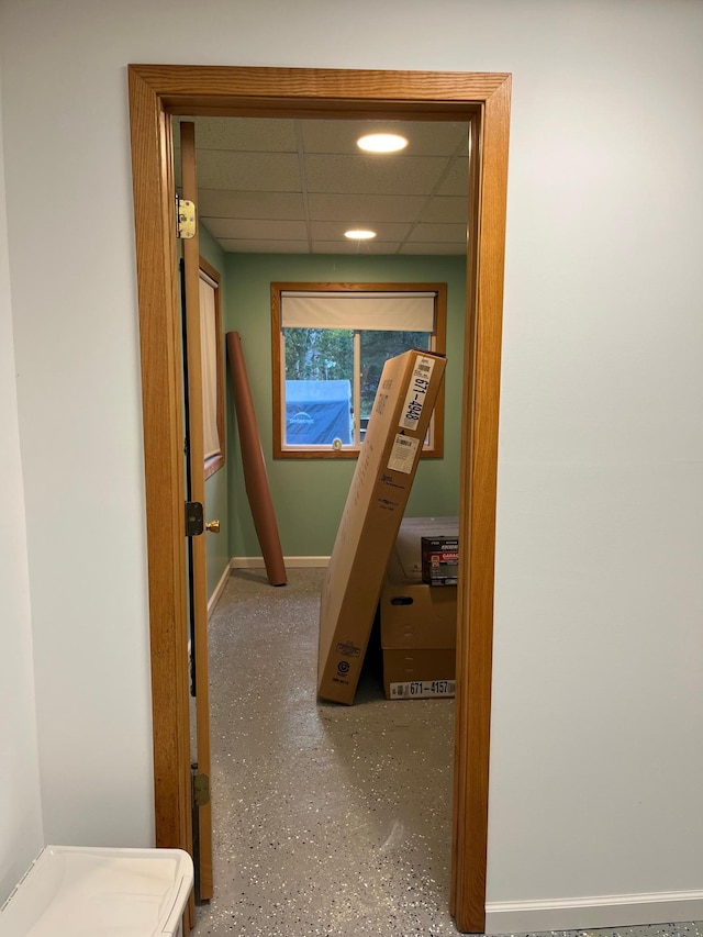 hall featuring a paneled ceiling