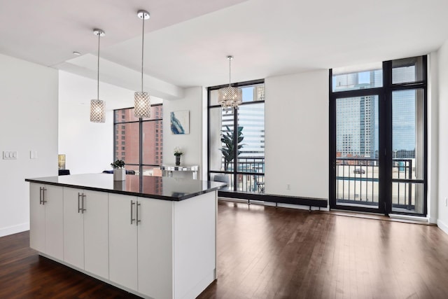 kitchen with white cabinets, plenty of natural light, and hanging light fixtures