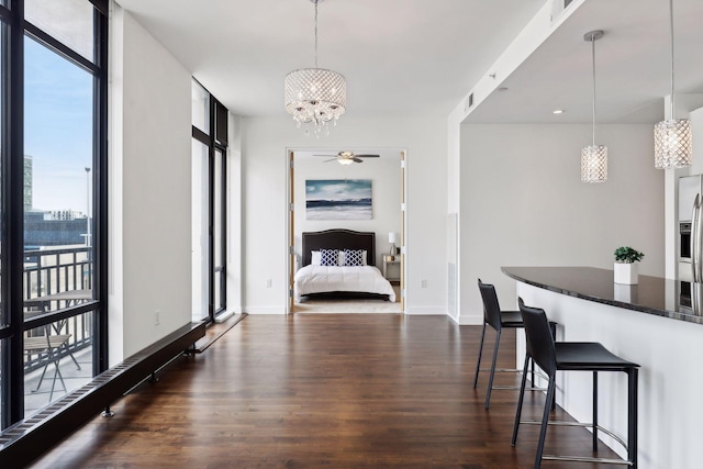 dining space with floor to ceiling windows, a healthy amount of sunlight, and dark wood-style flooring