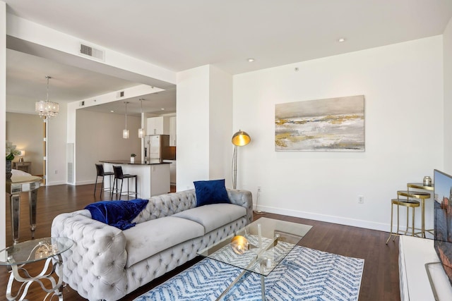 living area with a notable chandelier, baseboards, visible vents, and dark wood-style flooring