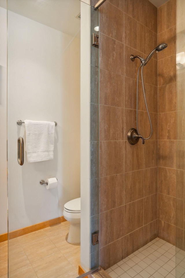 full bathroom featuring a shower stall, toilet, and baseboards