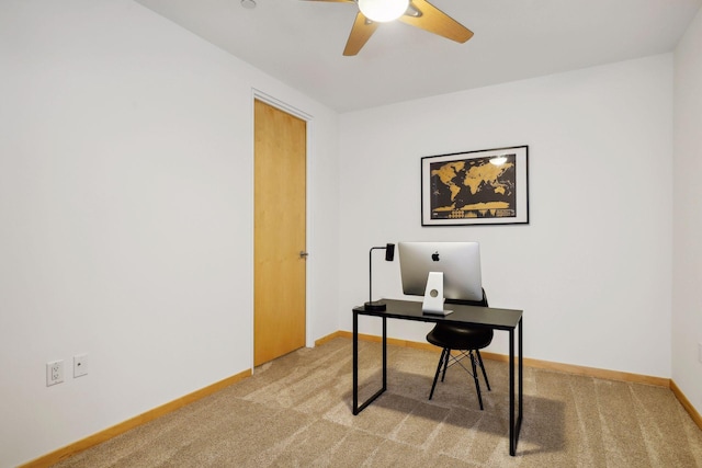 home office featuring a ceiling fan, light colored carpet, and baseboards