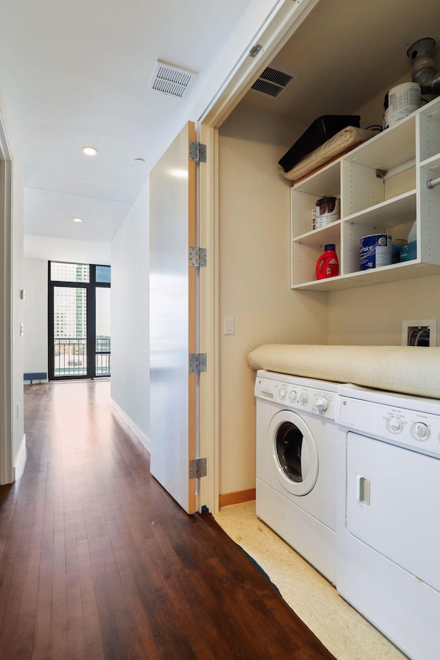 laundry area with visible vents, separate washer and dryer, wood finished floors, and laundry area