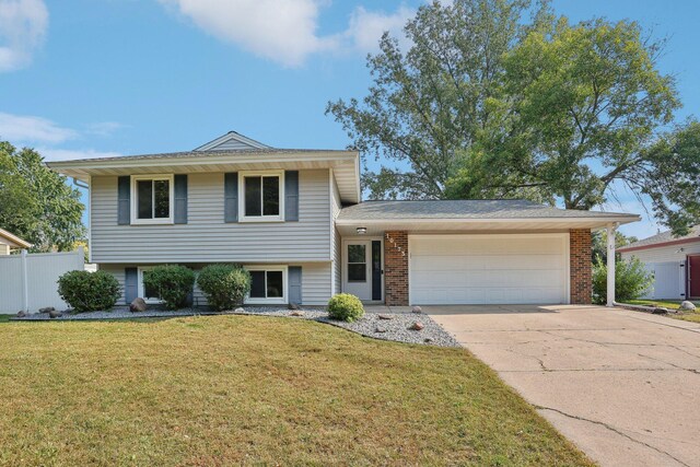 tri-level home with a garage and a front yard