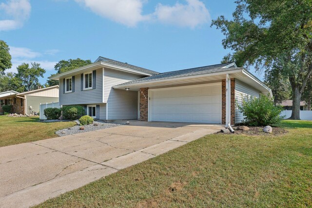 tri-level home featuring a front yard and a garage