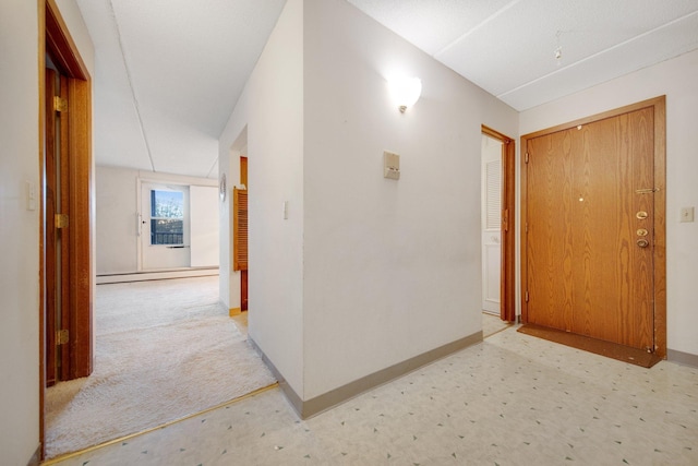 hallway featuring light colored carpet and a baseboard heating unit