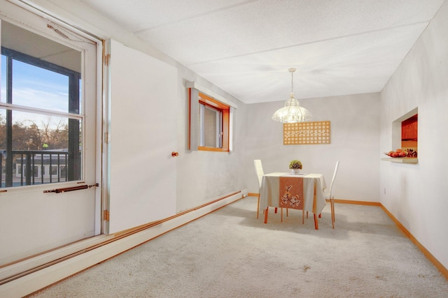 unfurnished dining area with baseboard heating, carpet floors, and a textured ceiling