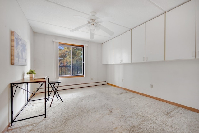 unfurnished office featuring baseboard heating, ceiling fan, and light colored carpet