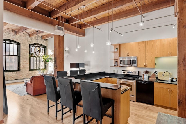 kitchen featuring wood ceiling, a breakfast bar area, brick wall, decorative light fixtures, and appliances with stainless steel finishes