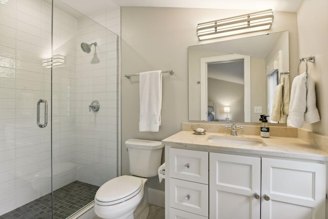 bathroom featuring vanity, toilet, and a shower with shower door