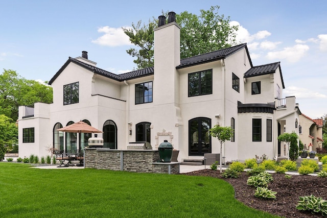 rear view of house with a yard, a patio area, and french doors