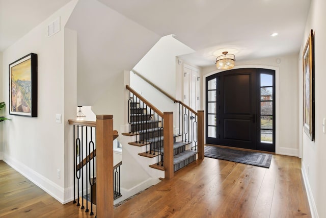 foyer featuring hardwood / wood-style floors and an inviting chandelier