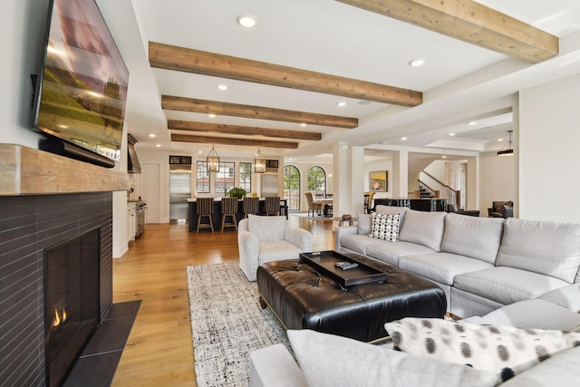 living room featuring light hardwood / wood-style floors and beamed ceiling