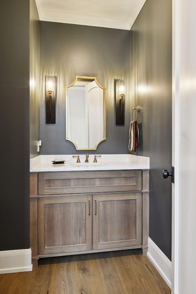 bathroom featuring hardwood / wood-style flooring, ornamental molding, and vanity