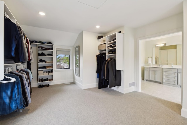 walk in closet featuring lofted ceiling and light carpet