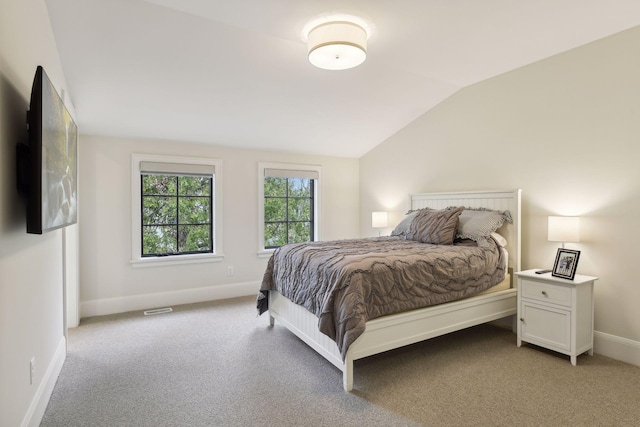 bedroom with lofted ceiling and light colored carpet