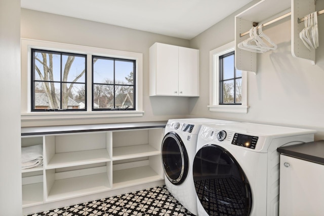 laundry area with separate washer and dryer and cabinets