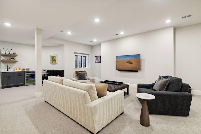 living room featuring light colored carpet, beverage cooler, and indoor bar