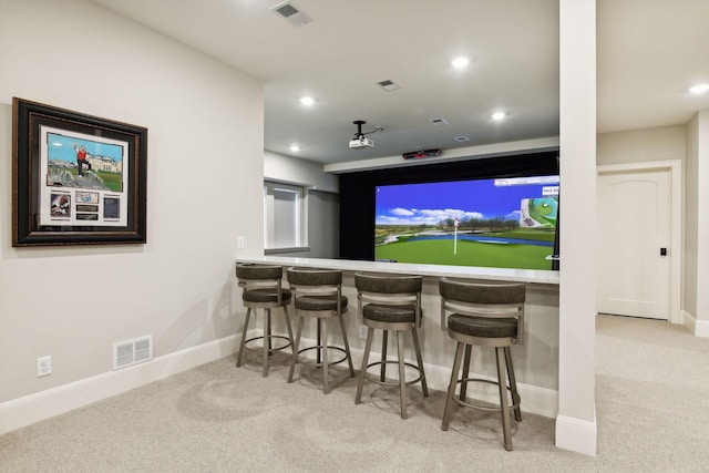 home theater room featuring light carpet and indoor bar