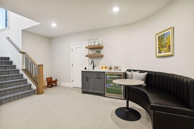 bar with gray cabinets, light colored carpet, and beverage cooler