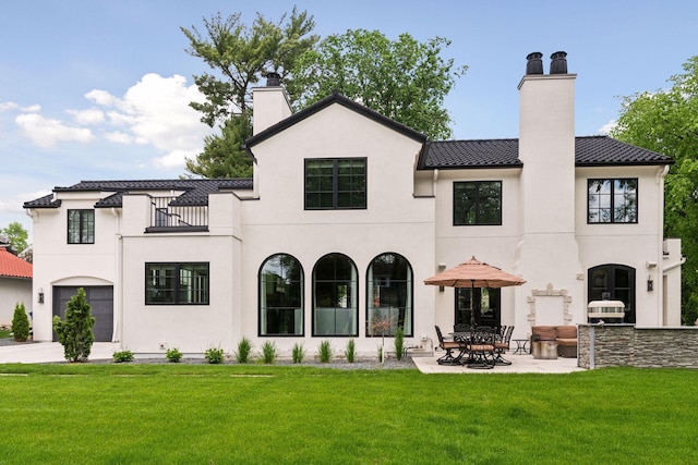 back of house featuring a yard, a patio, and a balcony